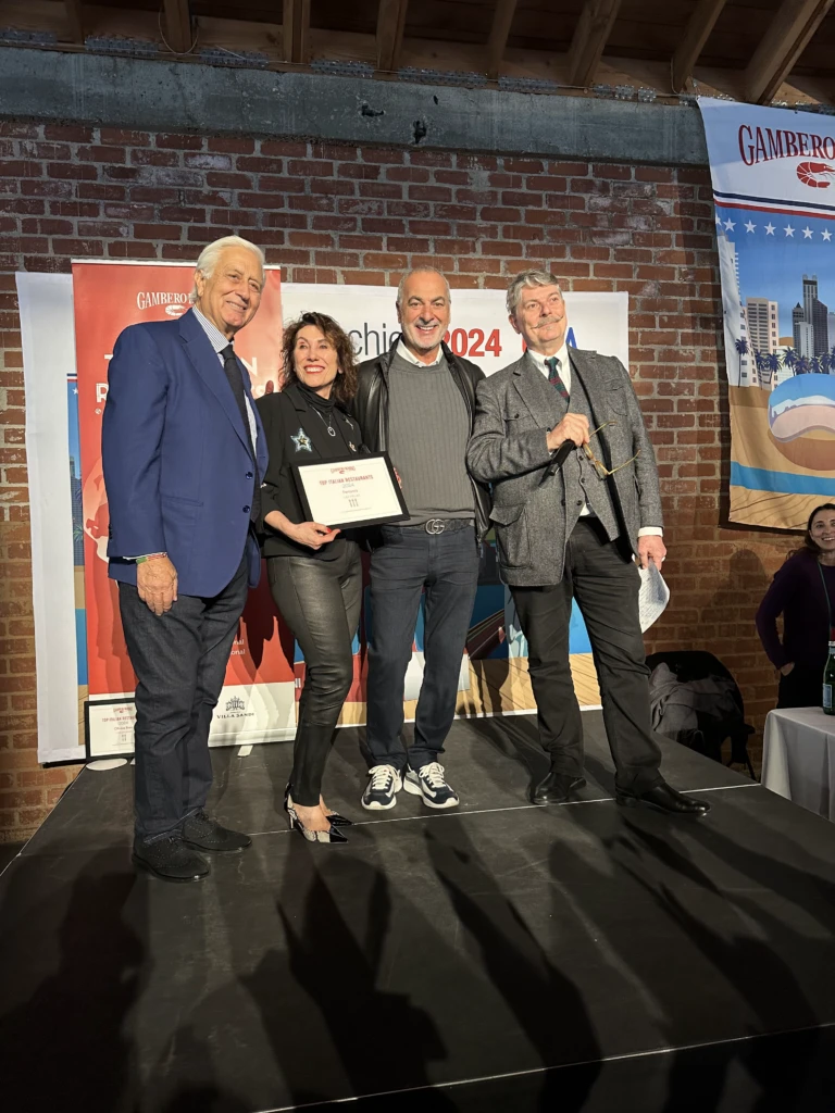 Gino Ferraro and colleagues on stage accepting the Gambero Rosso 2024 Top Italian Restaurants award for Ferraro's Ristorante in Las Vegas.